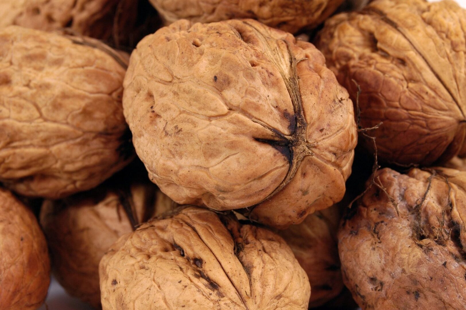 A pile of walnuts sitting on top of each other.